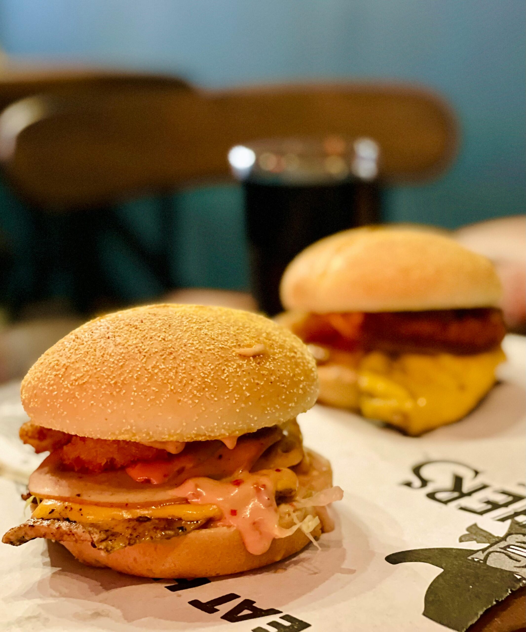 Mouthwatering close-up of delicious cheeseburgers with various toppings, perfect for fast food cravings.